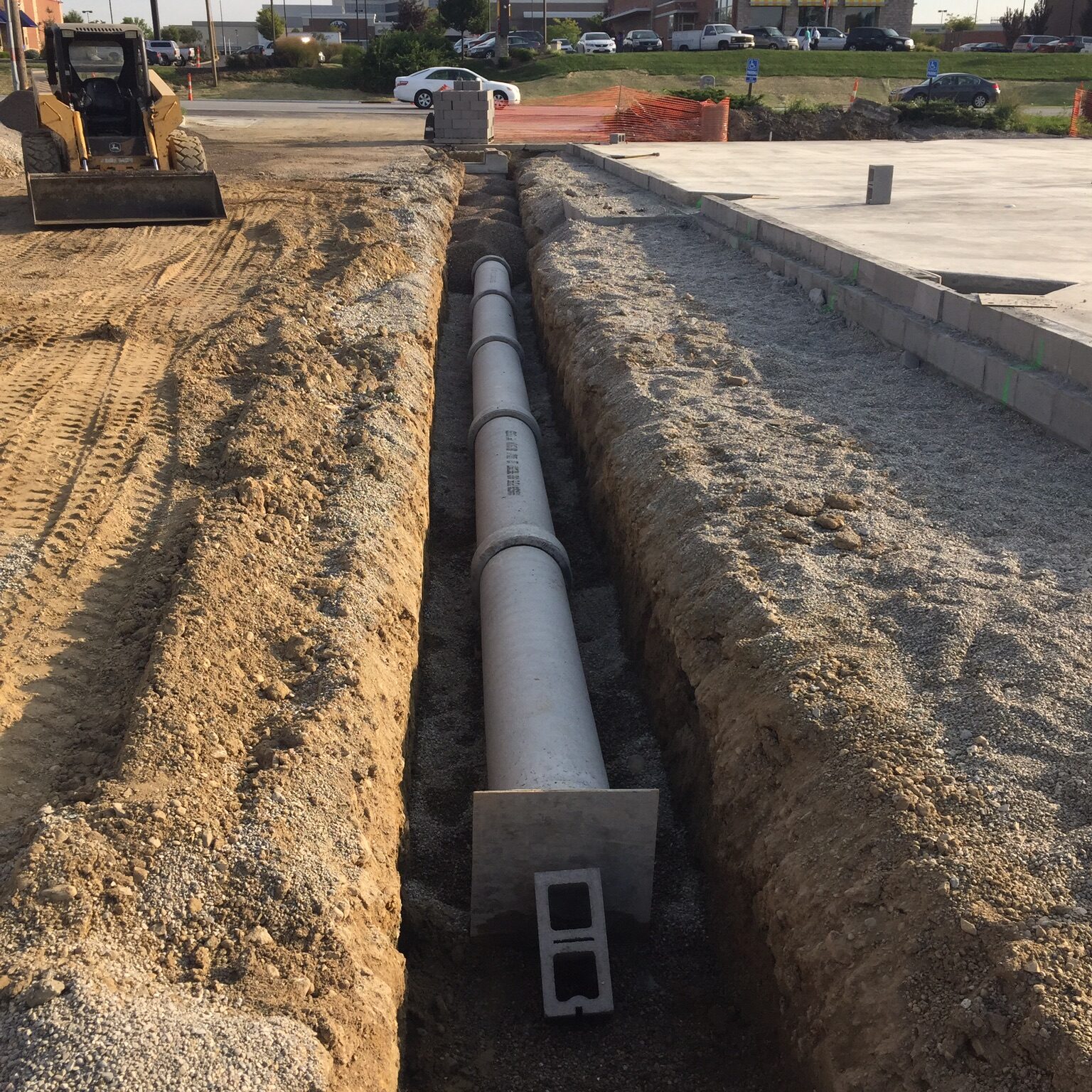 Concrete contractor digs trench for drainage and sitework